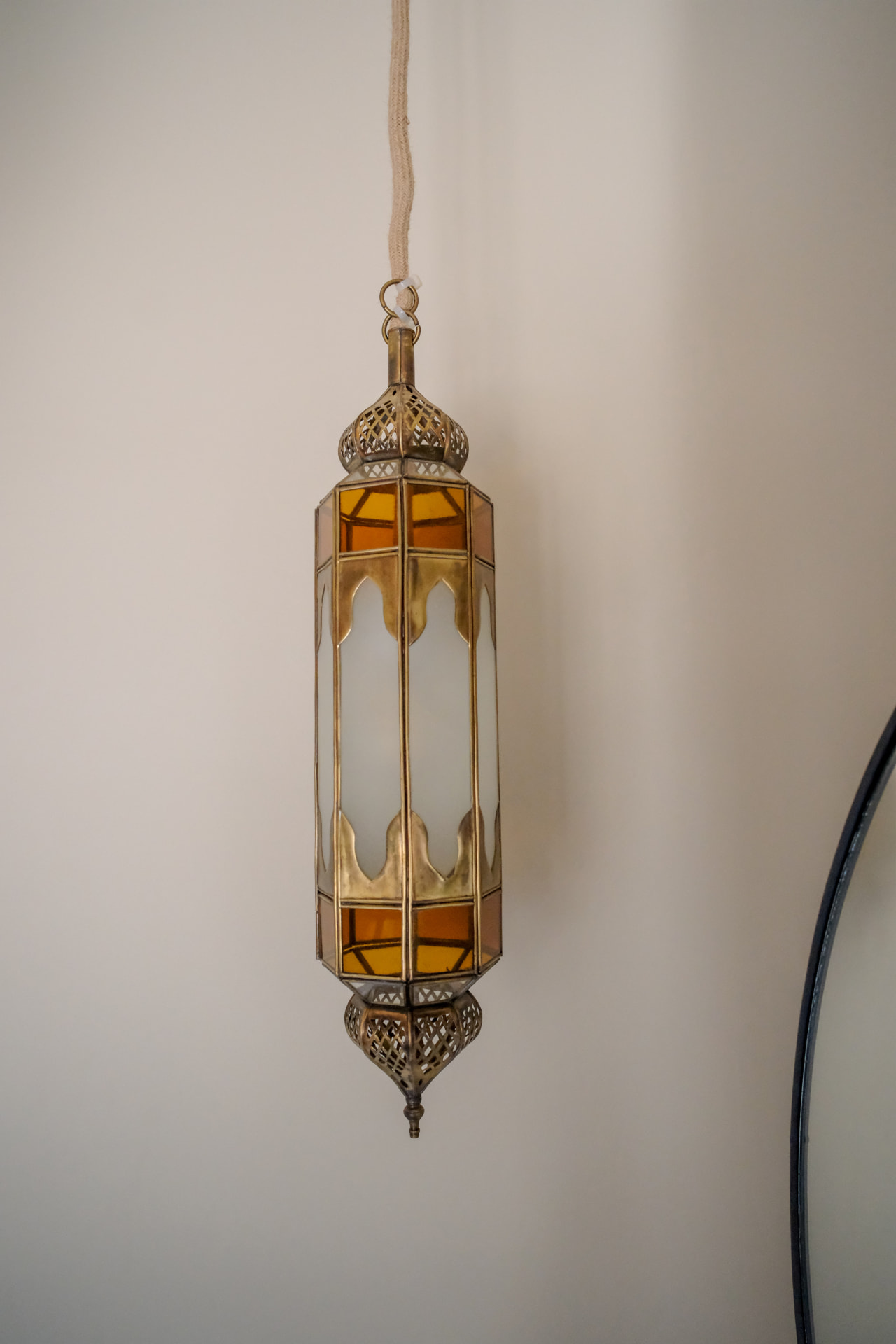 Detail, brass and glass hanging lantern beside the round mirror in the Upper Suite