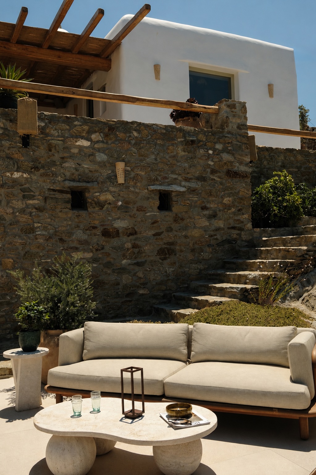 A modern beige sofa and organic stone coffee table on the sun-drenched poolside terrace