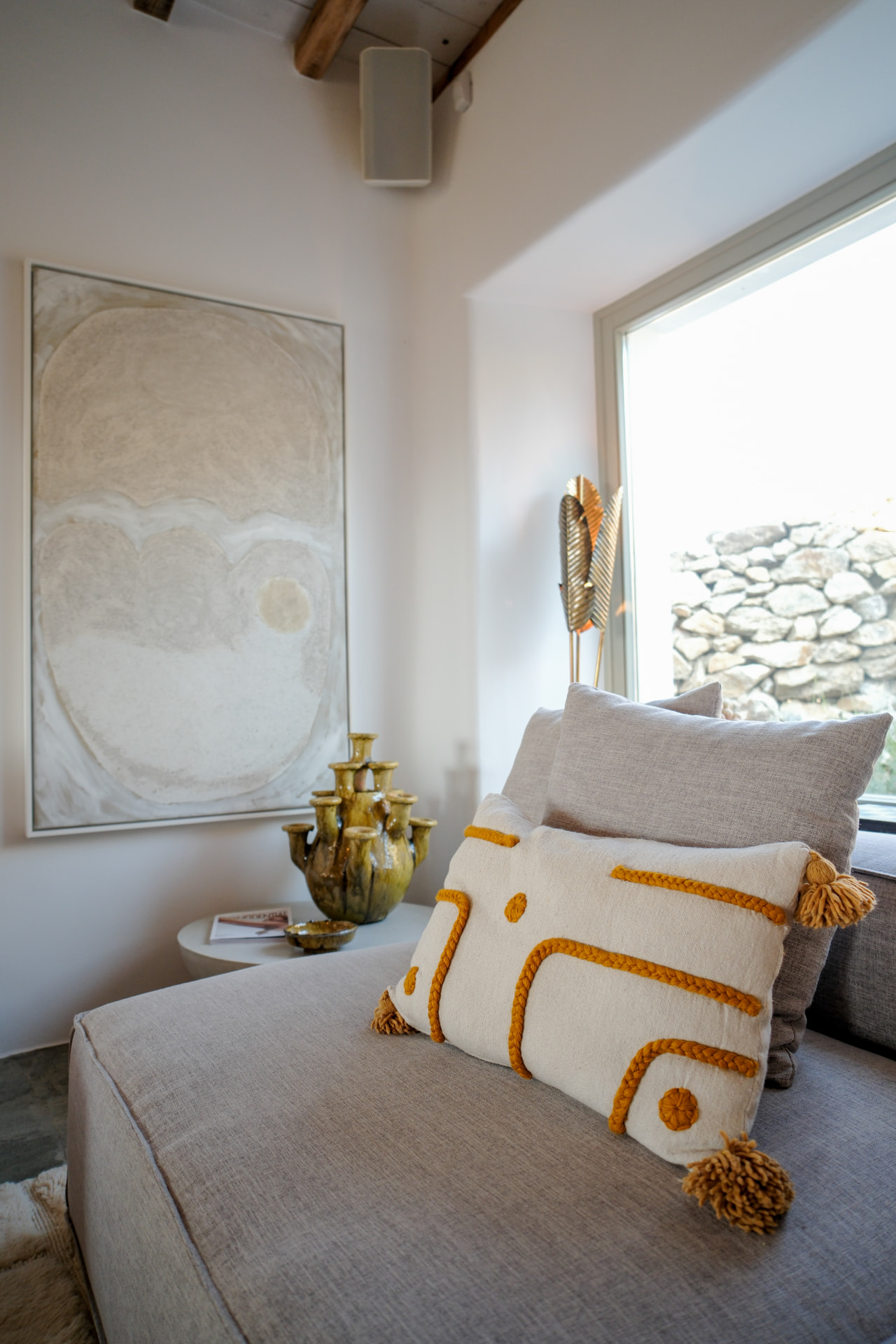 Detail, daybed with embroidered tasselled cushion and abstract painting