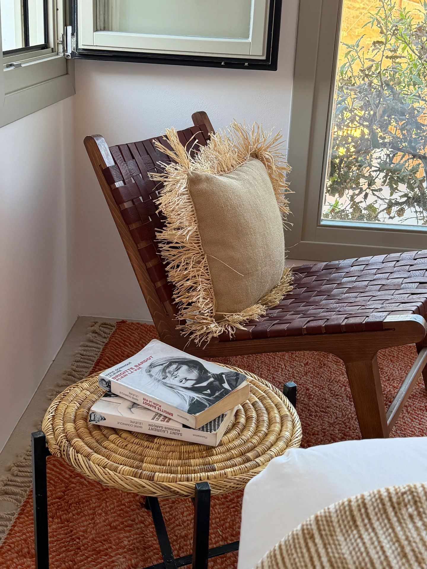 Detail, woven leather chair and raffia-fringed cushion in the Cycladic Suite