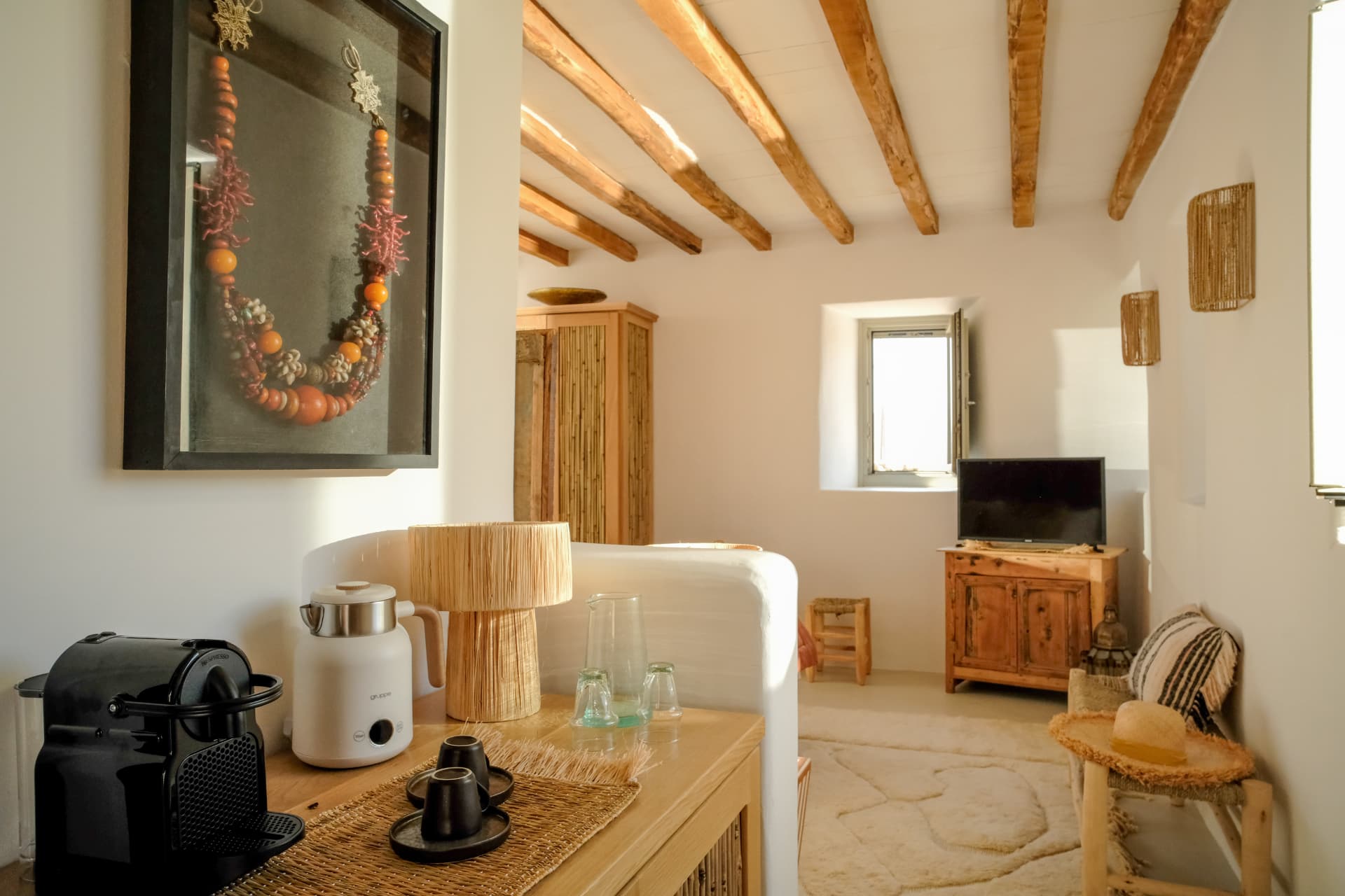The Stone Shepherd's House living area, coffee station and woven sconces beneath exposed beams