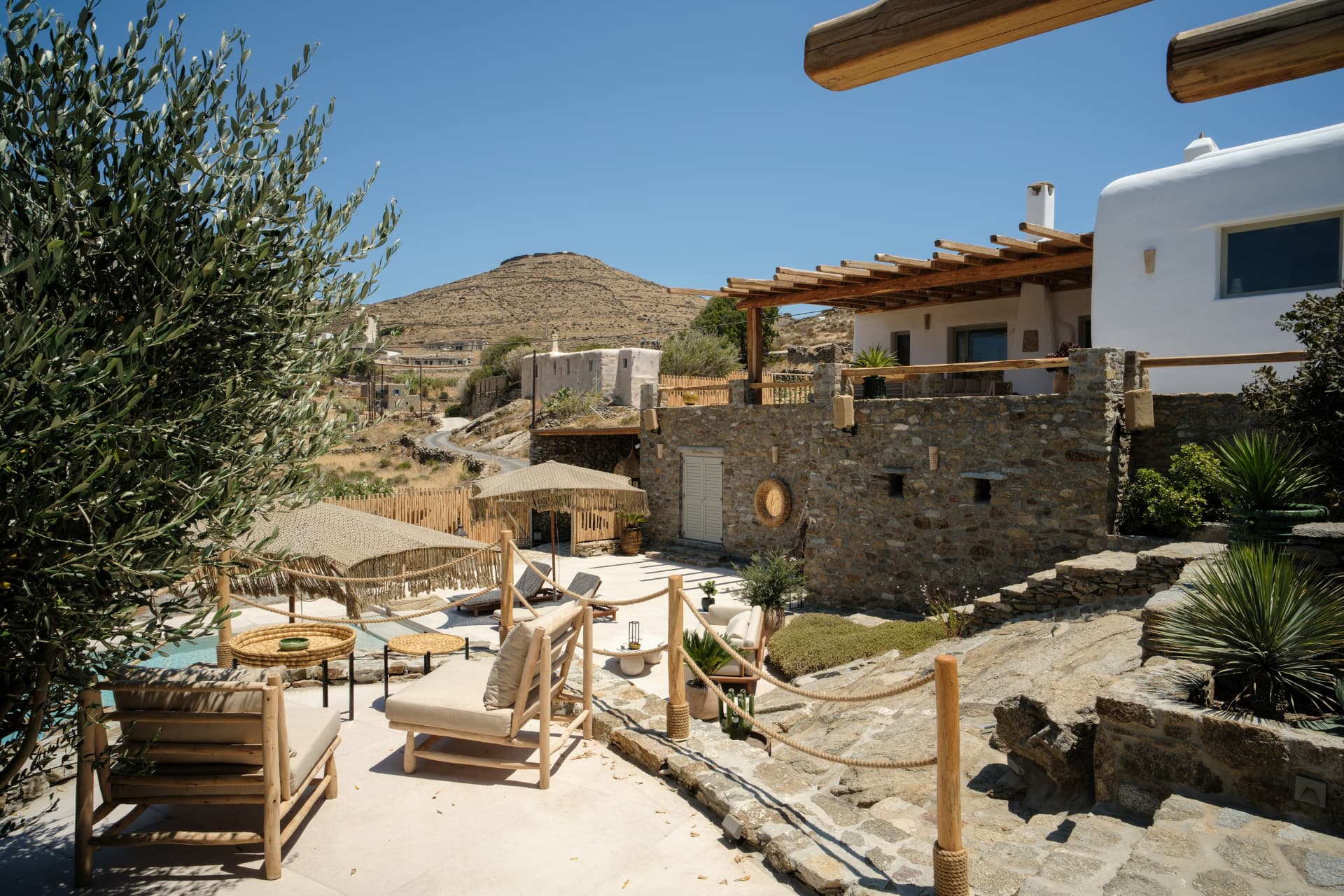 Multi-level terraces, passages and patios of Villa Storia linking stone buildings under a blue sky