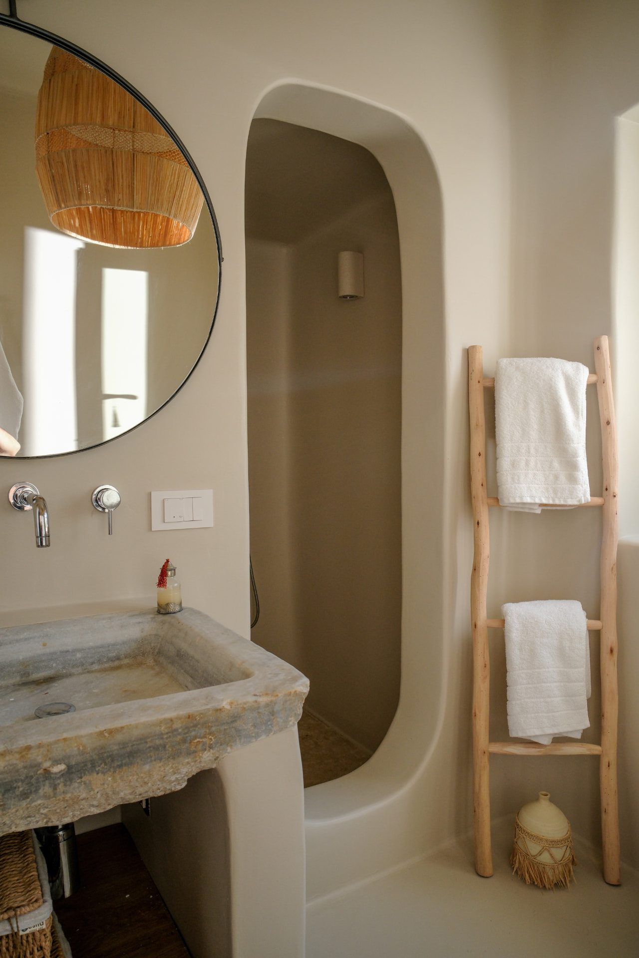 Detail, natural materials in the Upper Suite — carved stone basin, arched shower and wooden towel ladder