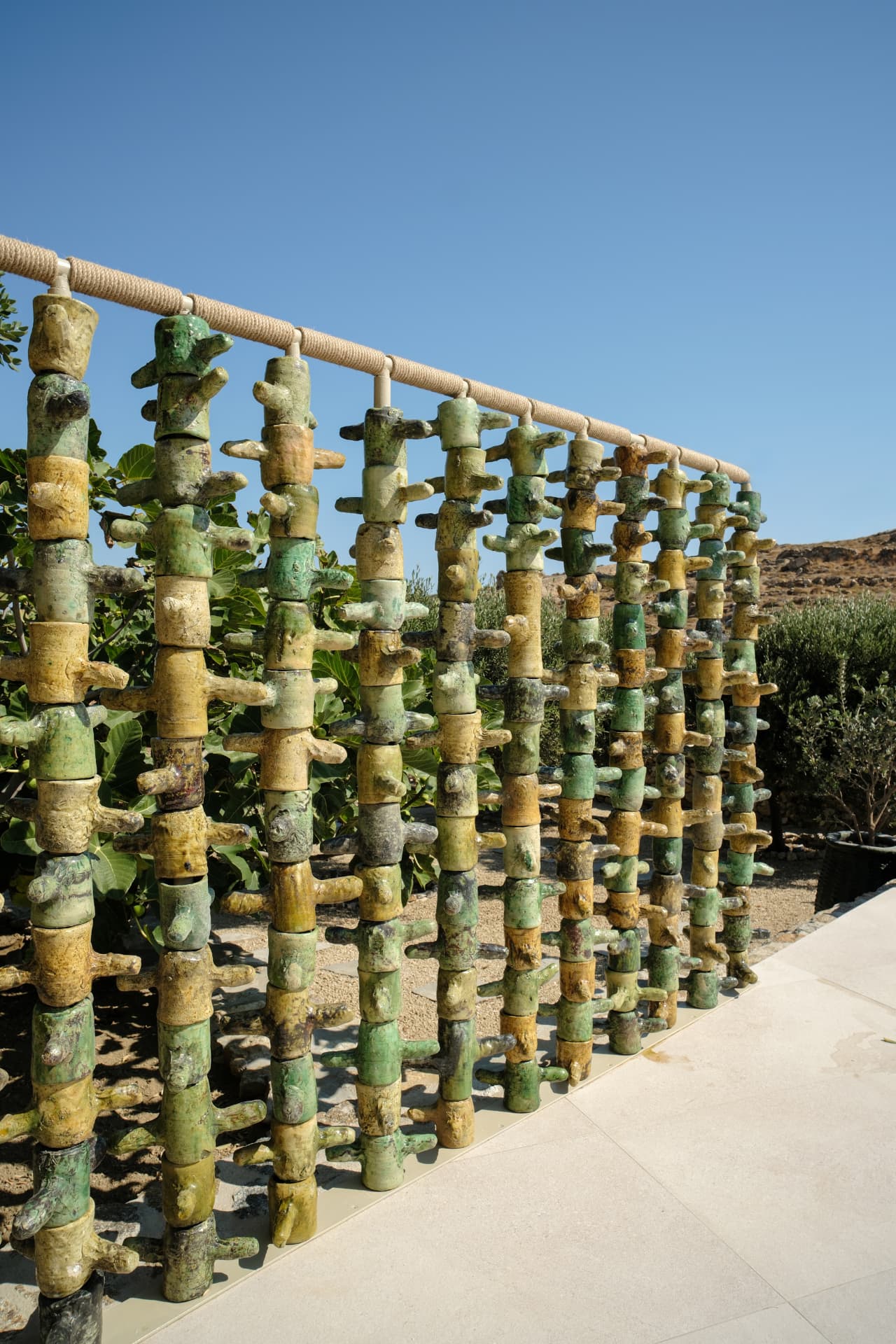 A decorative stacked ceramic screen on the poolside stone patio